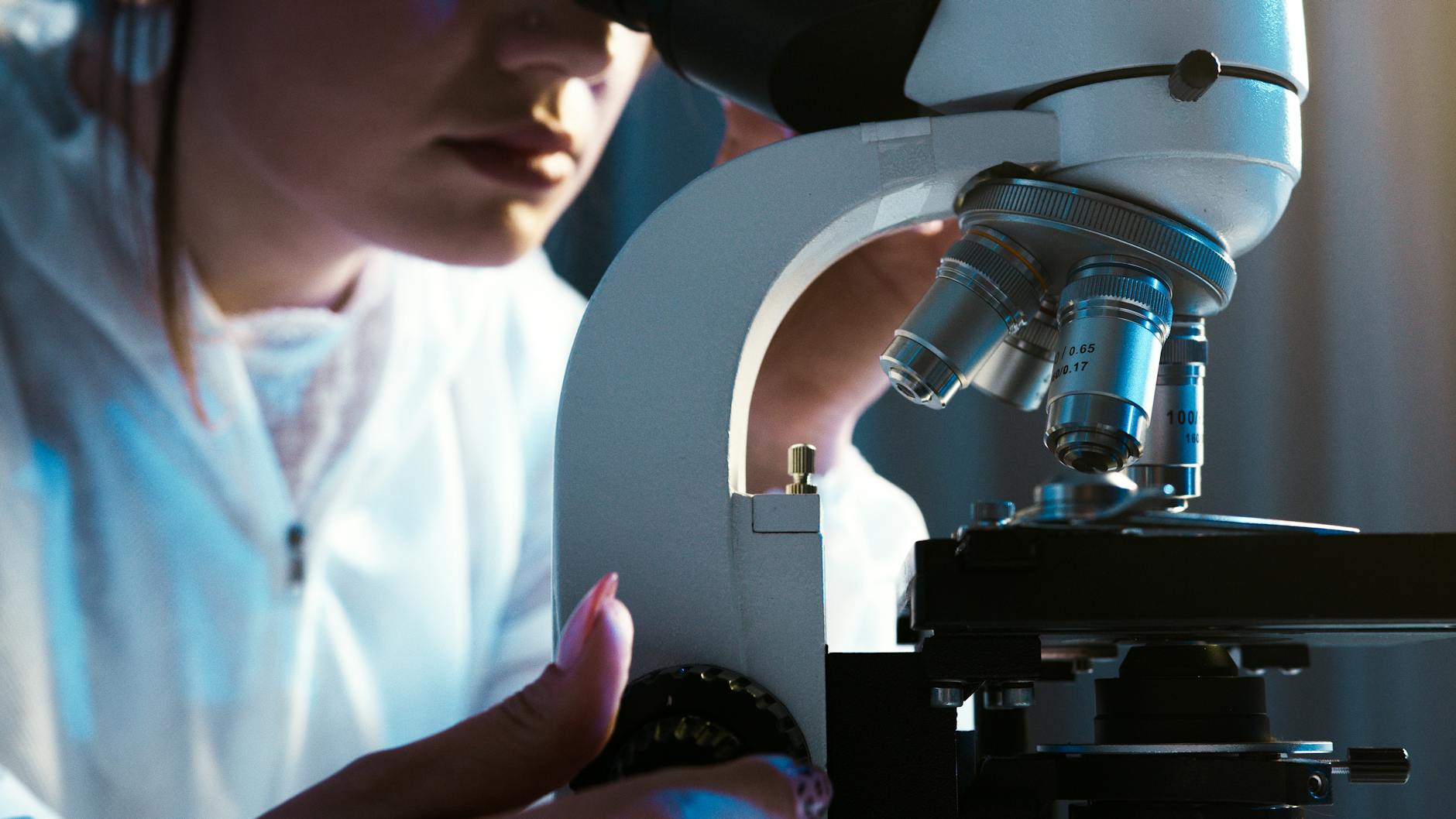 person looking through the microscope