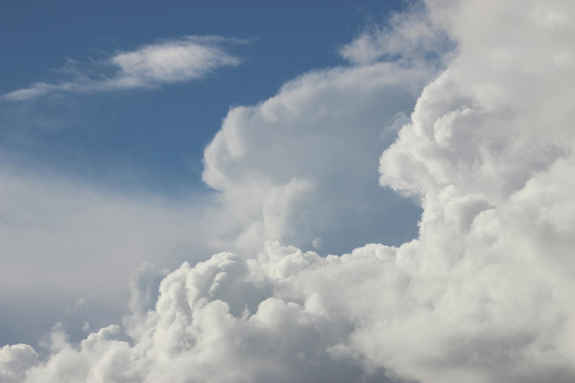 fluffy white clouds against clear blue sky